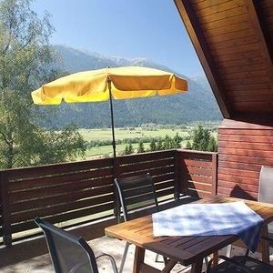 Ein Tisch mit Stühlen steht auf einem Balkon