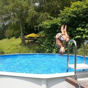 Ein junge springt kopfüber in ein Pool