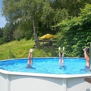Drei Kinder machen einen Kopfstand im Pool