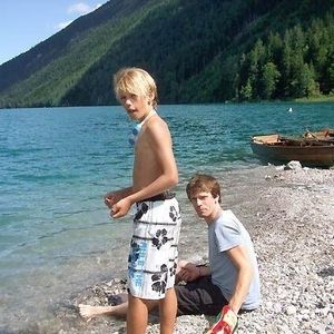 Zwei Jungen sitzen vor blauem Wasser