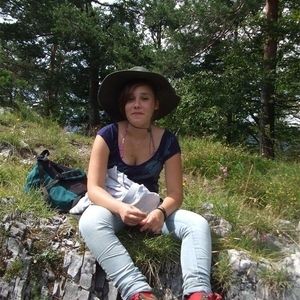 Ein Mädchen sitzt auf einem Stein
