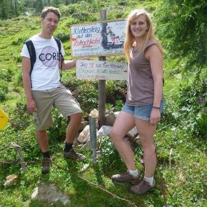 Two people standing in front of a sign